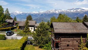 A mountain village with traditional wooden houses, a paved driveway, and a view of snow-capped mountains. - Victoria by Interhome (Vercorin)