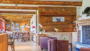 A rustic interior with exposed wooden beams, a fireplace, and a dining area with wooden furniture. - Victoria by Interhome (Vercorin)