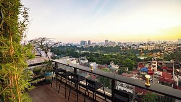 A rooftop terrace with a city view, including a river and buildings.