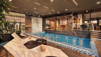 Area piscina con lettini, vasca idromassaggio e zona bar.