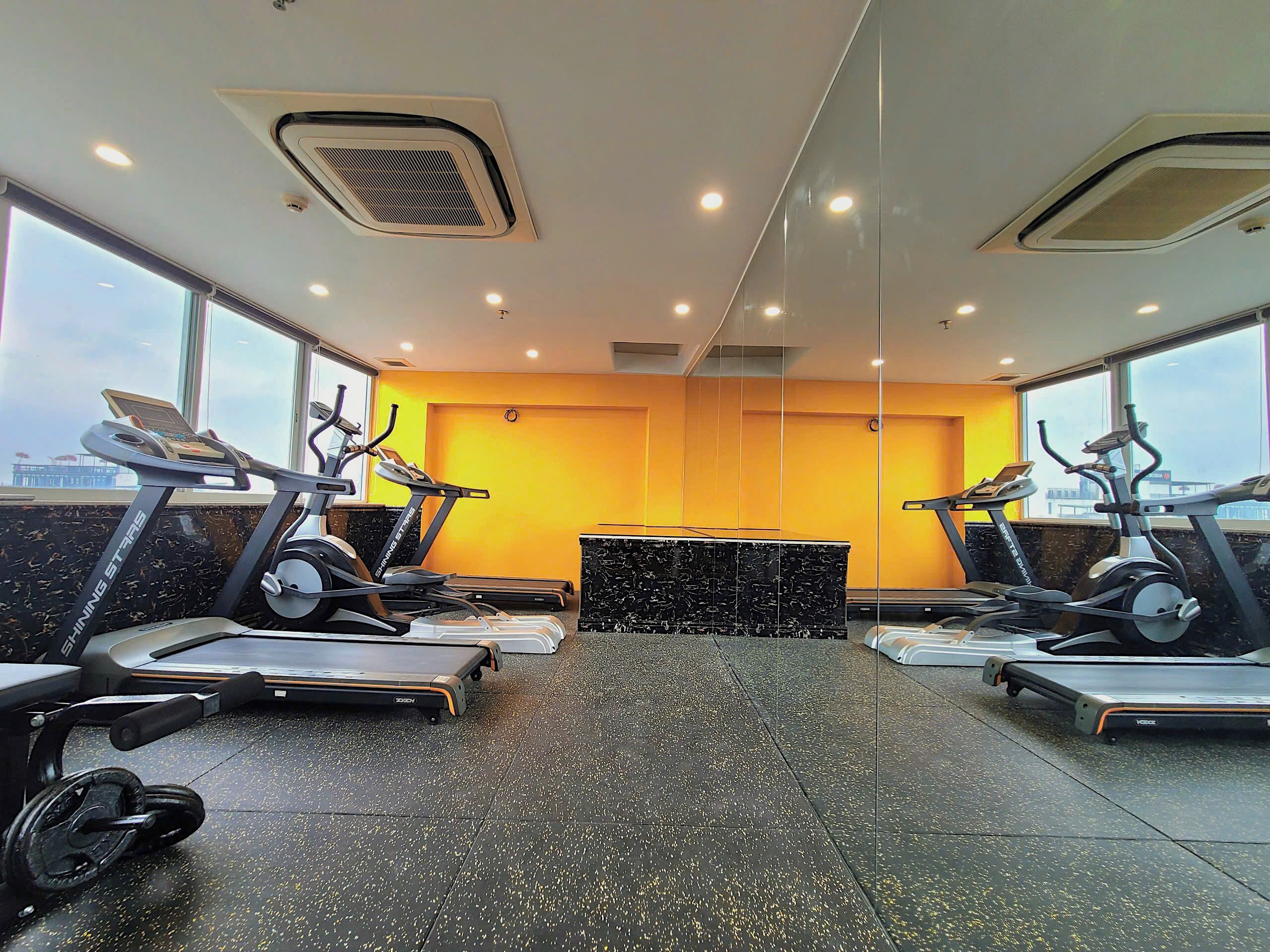 A gym with treadmills, a stationary bike, and a weight bench.