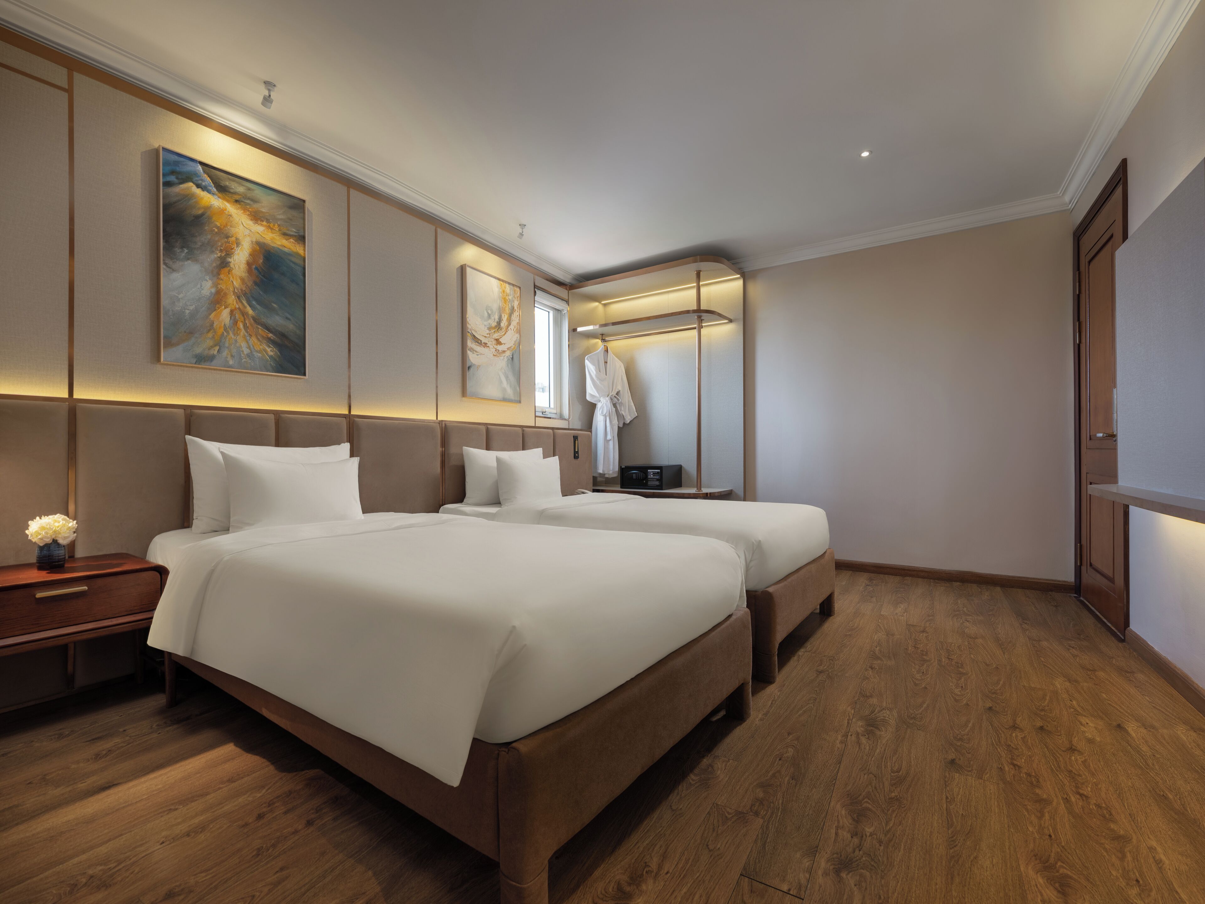 A modern hotel room with two beds, a large mirror, and artwork on the walls.