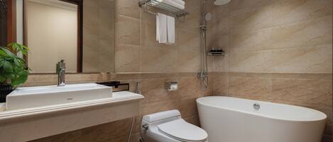 A modern bathroom with a freestanding bathtub, a toilet, and a sink with a mirror.