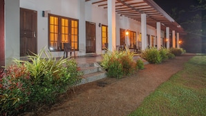 A building with multiple doors and windows, a covered porch, and a well-maintained garden with steps leading to the entrance. - The Regency villa by Escape Essence  (Unawatuna)