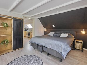 Ein modernes Schlafzimmer mit einem großen Bett, einem Einbauschrank und einem Oberlicht.
