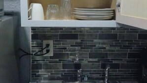 Een keuken met een inbouwspoelbak, een aanrecht en een spatwand.