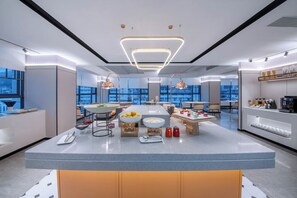 A modern kitchen with a central island, pendant lighting, and a view of the city. - Homeinn Plus - Zhangjiajie Tianmenshan (Zhangjiajie)