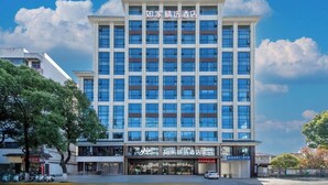 A multi-story hotel with a modern facade, large windows, and a prominent entrance with signage. - Homeinn Plus - Zhangjiajie Tianmenshan (Zhangjiajie)