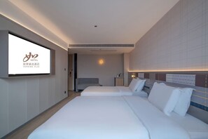 A modern hotel room with two beds, a TV screen displaying the hotel logo, and a large window. - Homeinn Plus - Zhangjiajie Tianmenshan (Zhangjiajie)