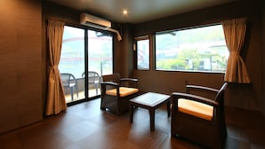 A room with a view of a bridge, wicker furniture, and an air conditioning unit. - Myoukenkan (Kirishima)