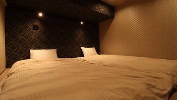 Un dormitorio con pared estampada, una cama grande con ropa de cama blanca e iluminación empotrada.