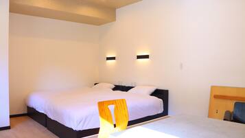 A modern bedroom with a large bed, two bedside tables, and a wooden headboard.