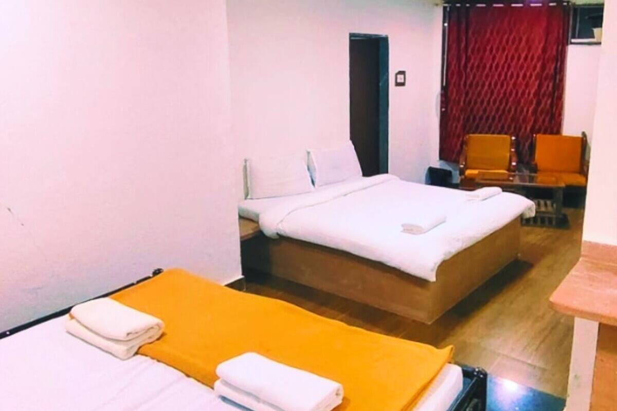 Habitación de hotel con dos camas, un escritorio y una silla.