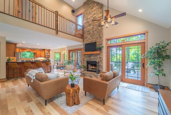 A spacious living area with a fireplace, a dining area, and a kitchen.
