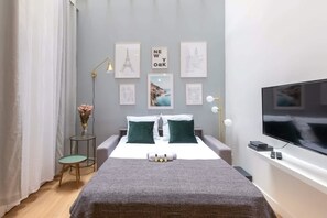 Relax in this stylish bedroom with a comfortable bed, bedside table, and flat-screen TV.