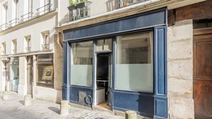 A building with a large glass storefront and a wooden door. - ParisConciergerie - 1BR apartment with AC (Paris)