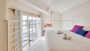 Een hotelkamer met een bed, kussens en handdoeken.