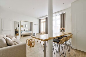 A modern apartment with a living area, dining space, and bedroom.
