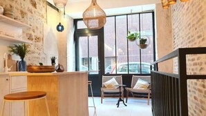 Una cocina moderna con una isla central, taburetes de madera e iluminación colgante.