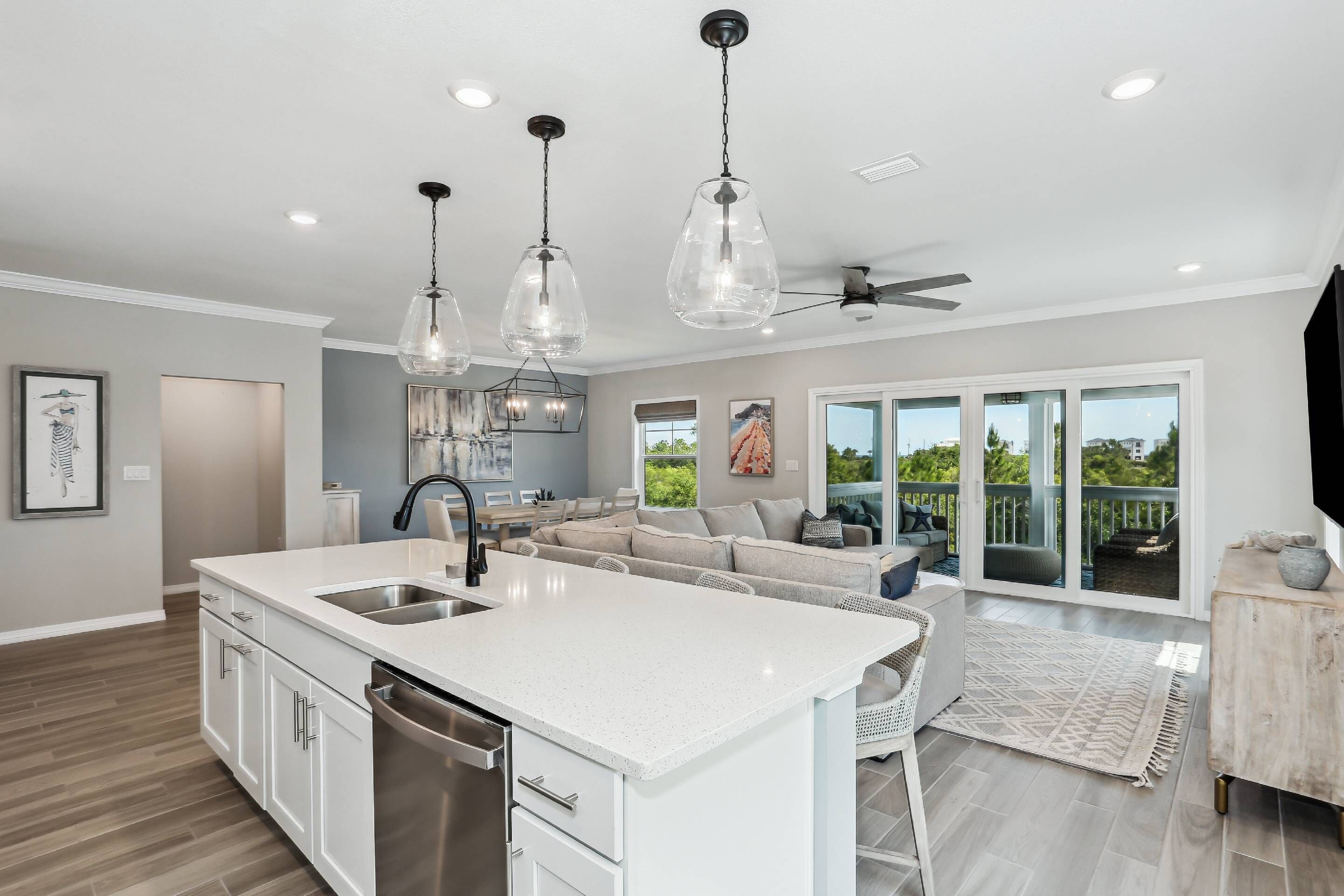 A modern kitchen with a central island, stainless steel appliances, and pendant lighting.