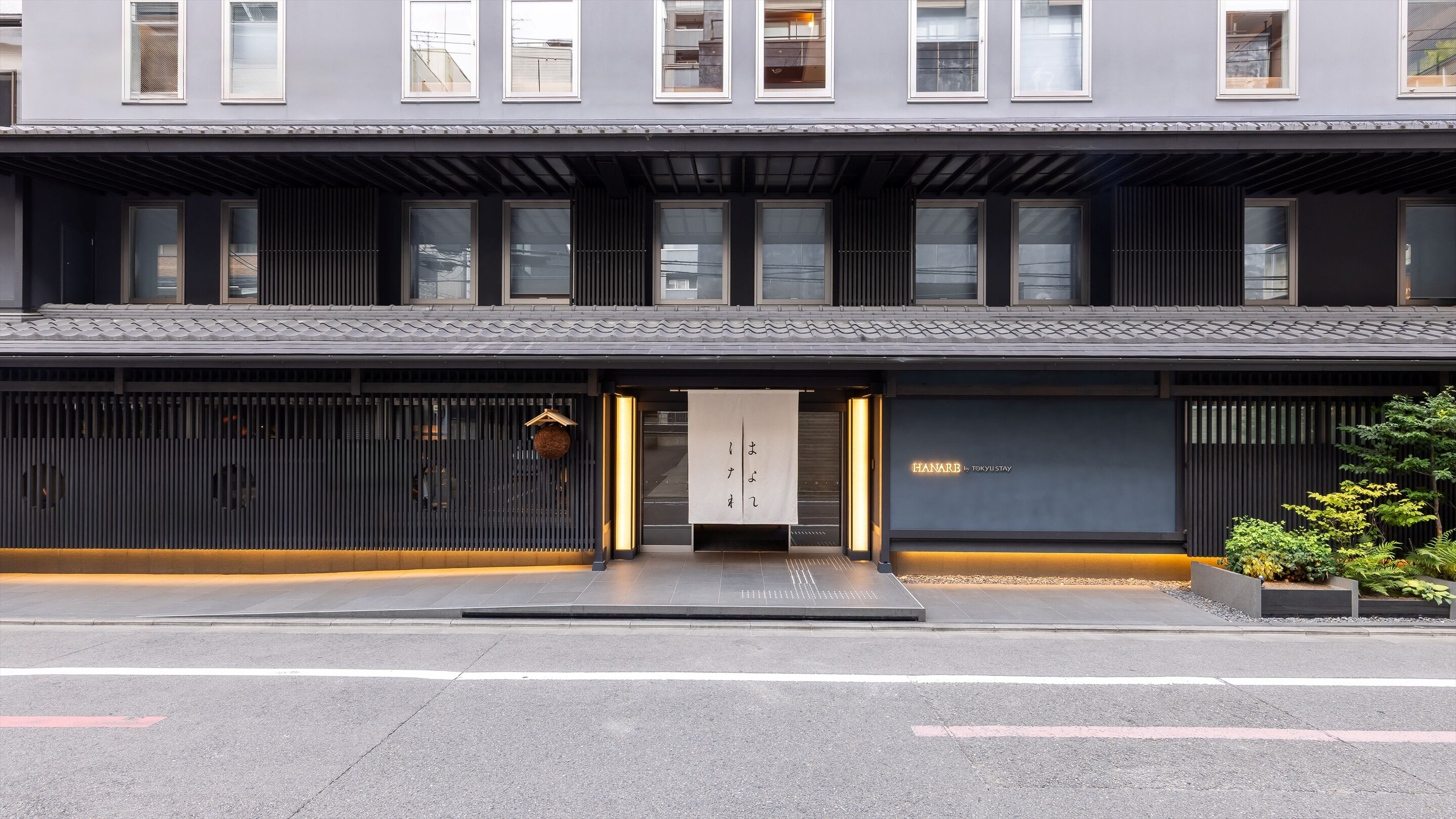 A modern hotel facade with a flat roof, large windows, and a minimalist entrance.