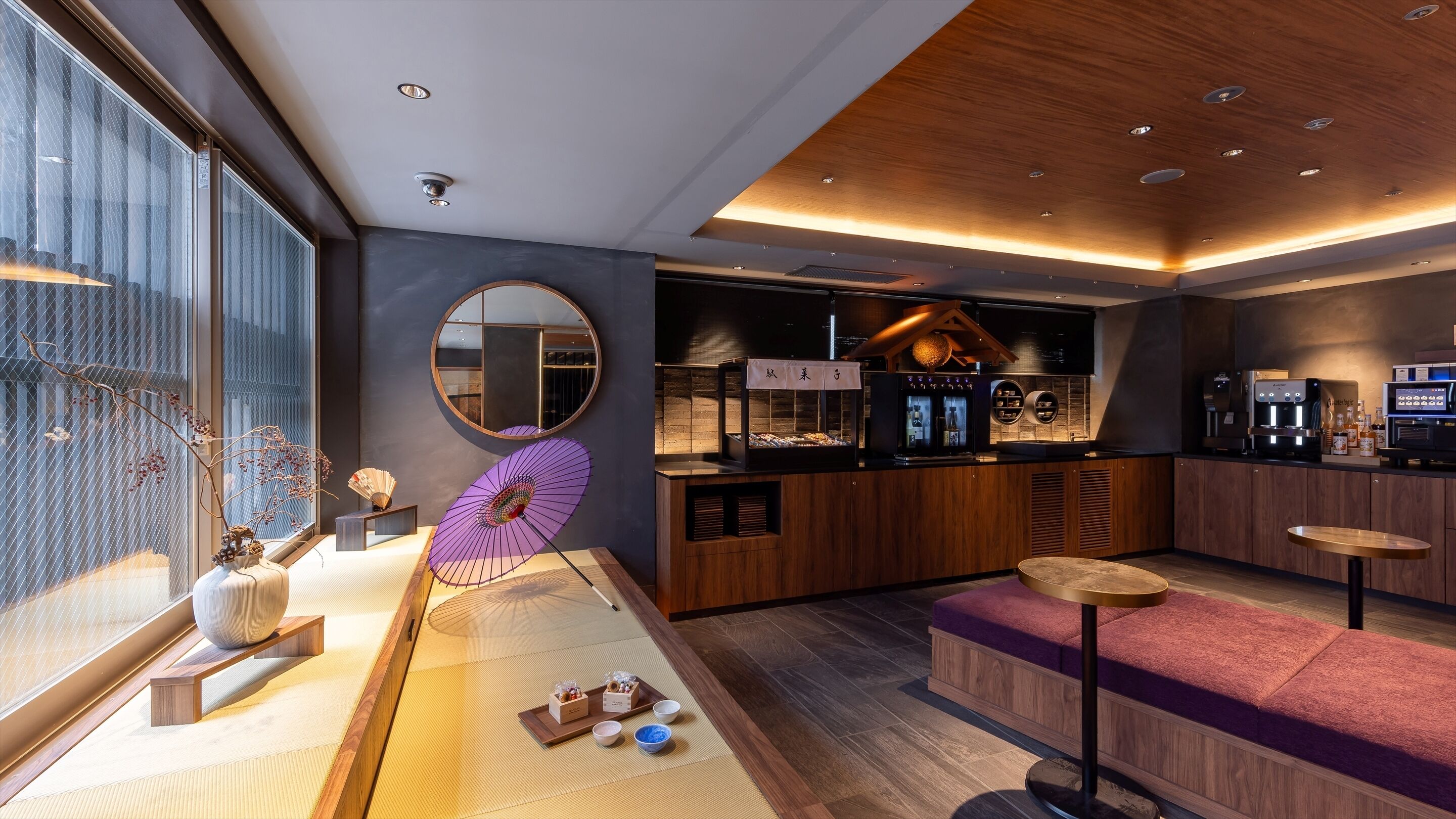 A modern interior with a wooden counter, a round mirror, and a seating area with a purple cushion.
