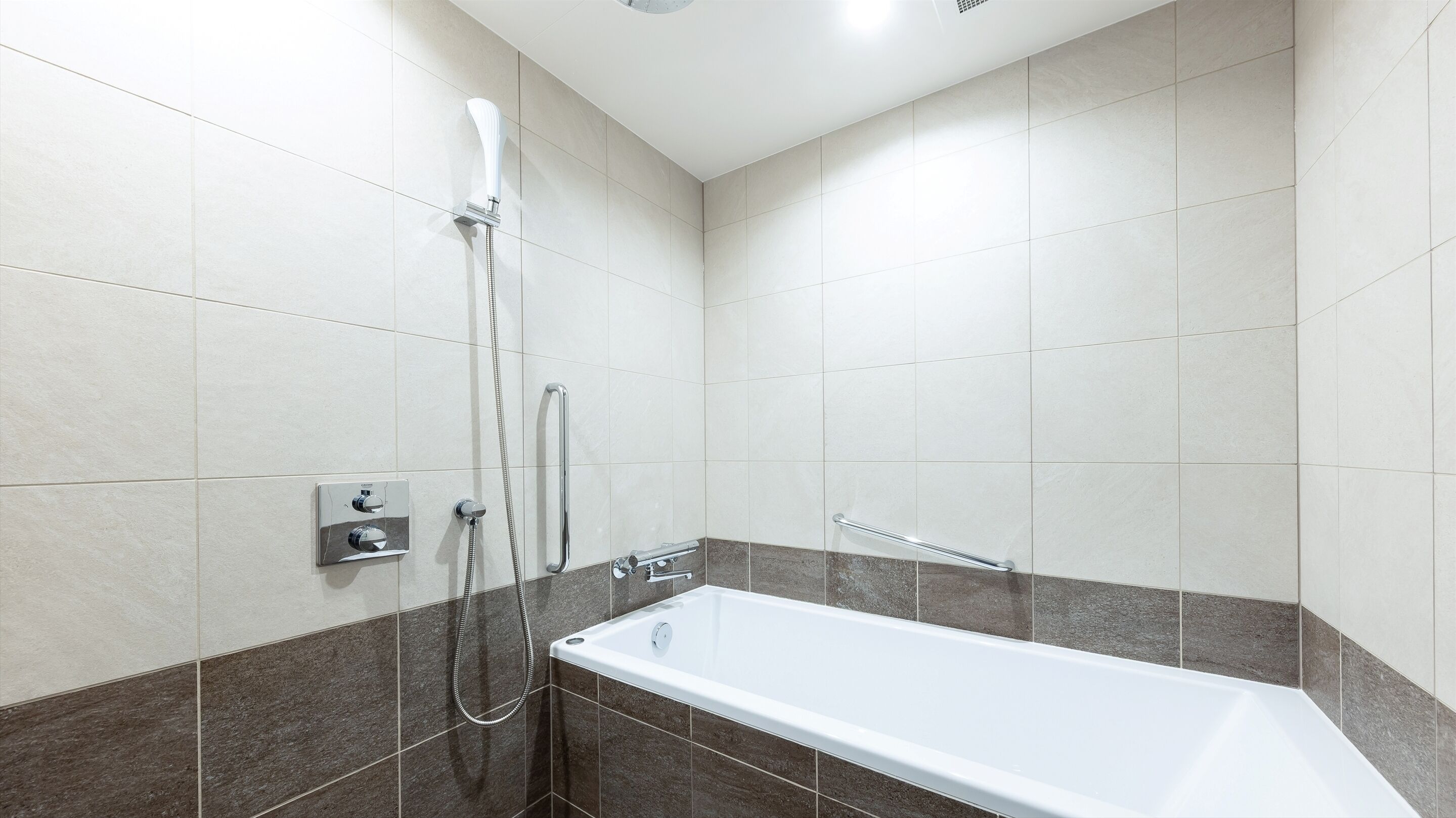 Un baño moderno con bañera, ducha y barandilla.