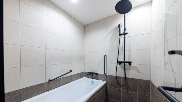 Un baño moderno con una bañera, una ducha y un cabezal de ducha de mano en la pared.
