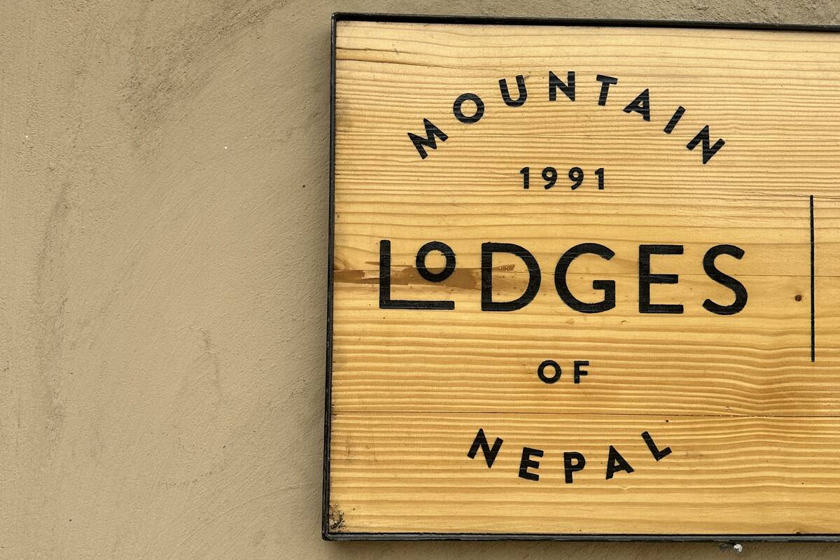 A wooden sign with the text "MOUNTAIN LODGES OF NEPAL 1991".
