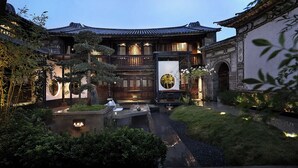 Il s’agit d’un bâtiment japonais traditionnel, doté d’une façade en bois, d’un jardin central agrémenté d’un bassin à carpes koï et d’une grande œuvre d’art encadrée accrochée au mur.