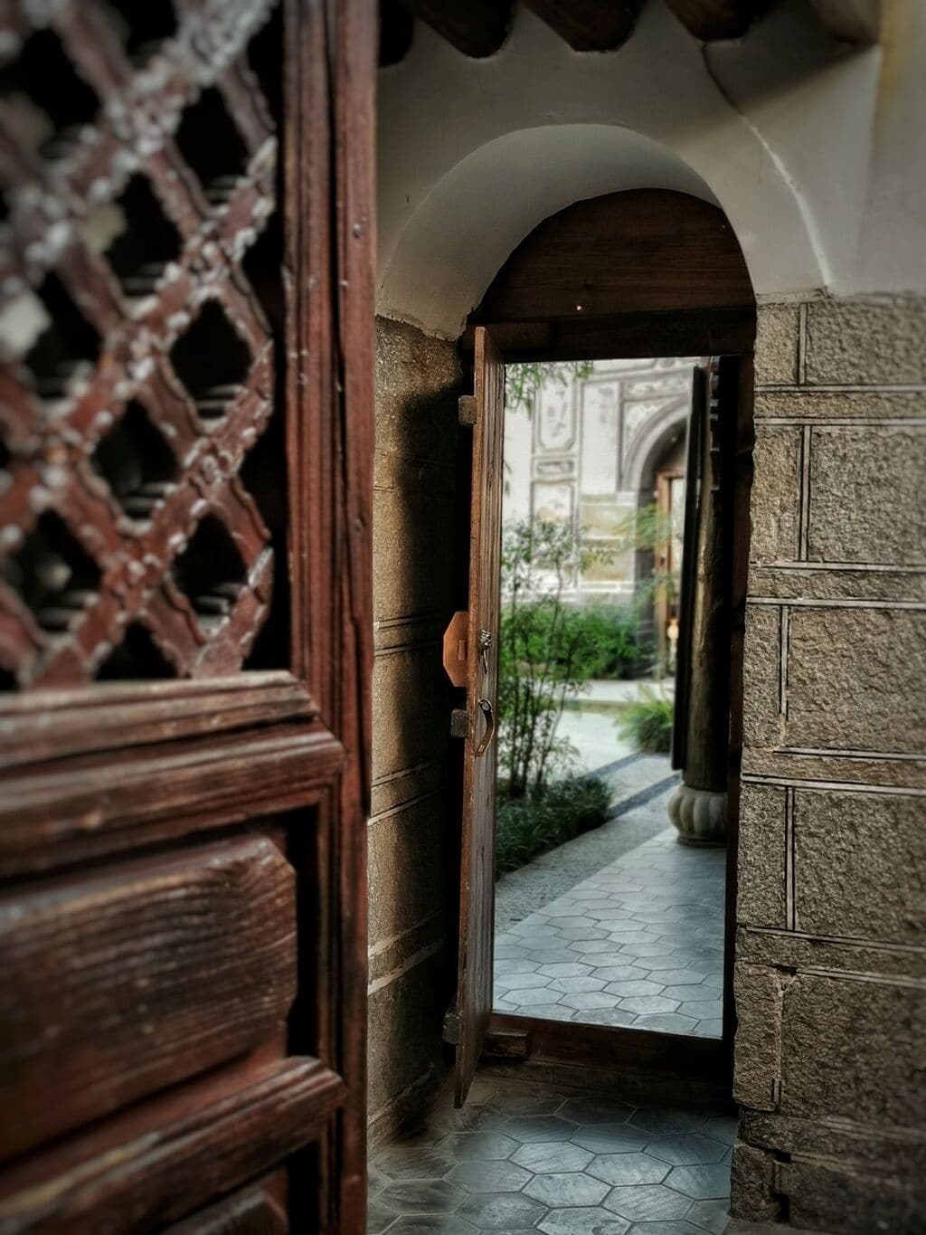 Un arco de entrada que da a un patio con un sendero empedrado.