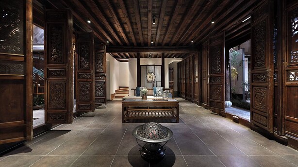 Un intérieur traditionnel avec des boiseries, une table centrale et un lampadaire décoratif.