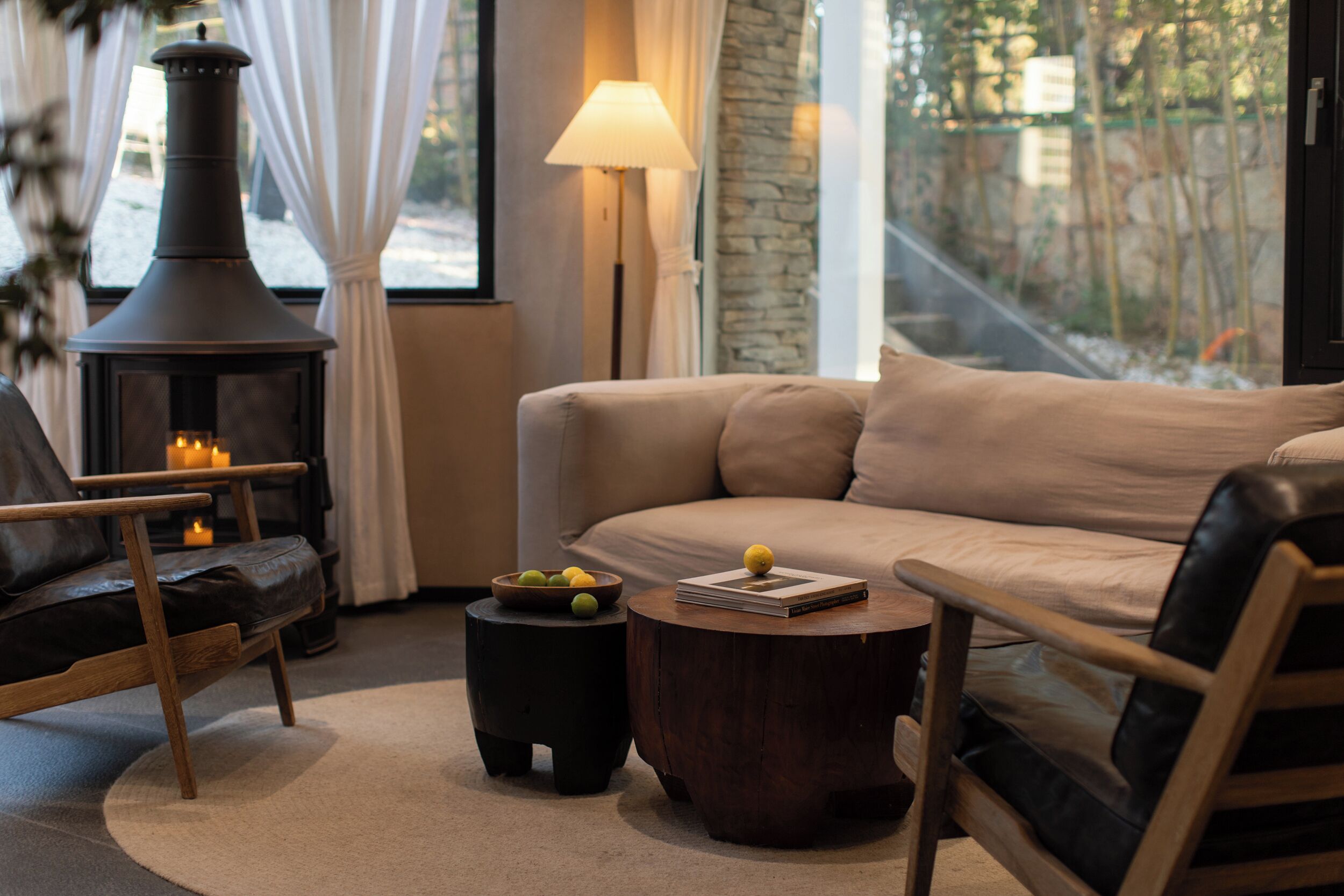 Una sala de estar acogedora con chimenea, un sofá, una mesa de centro y una lámpara.