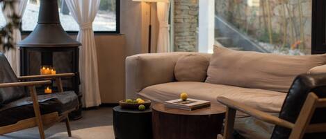 Ein gemütliches Wohnzimmer mit Kamin, einer Couch, einem Couchtisch und einer Lampe.