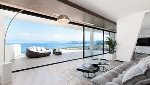 A modern living room with a large sliding glass door leading to a balcony with a city view. - Anyu Aranya Collection Sea View Resort Hotel (Dali)