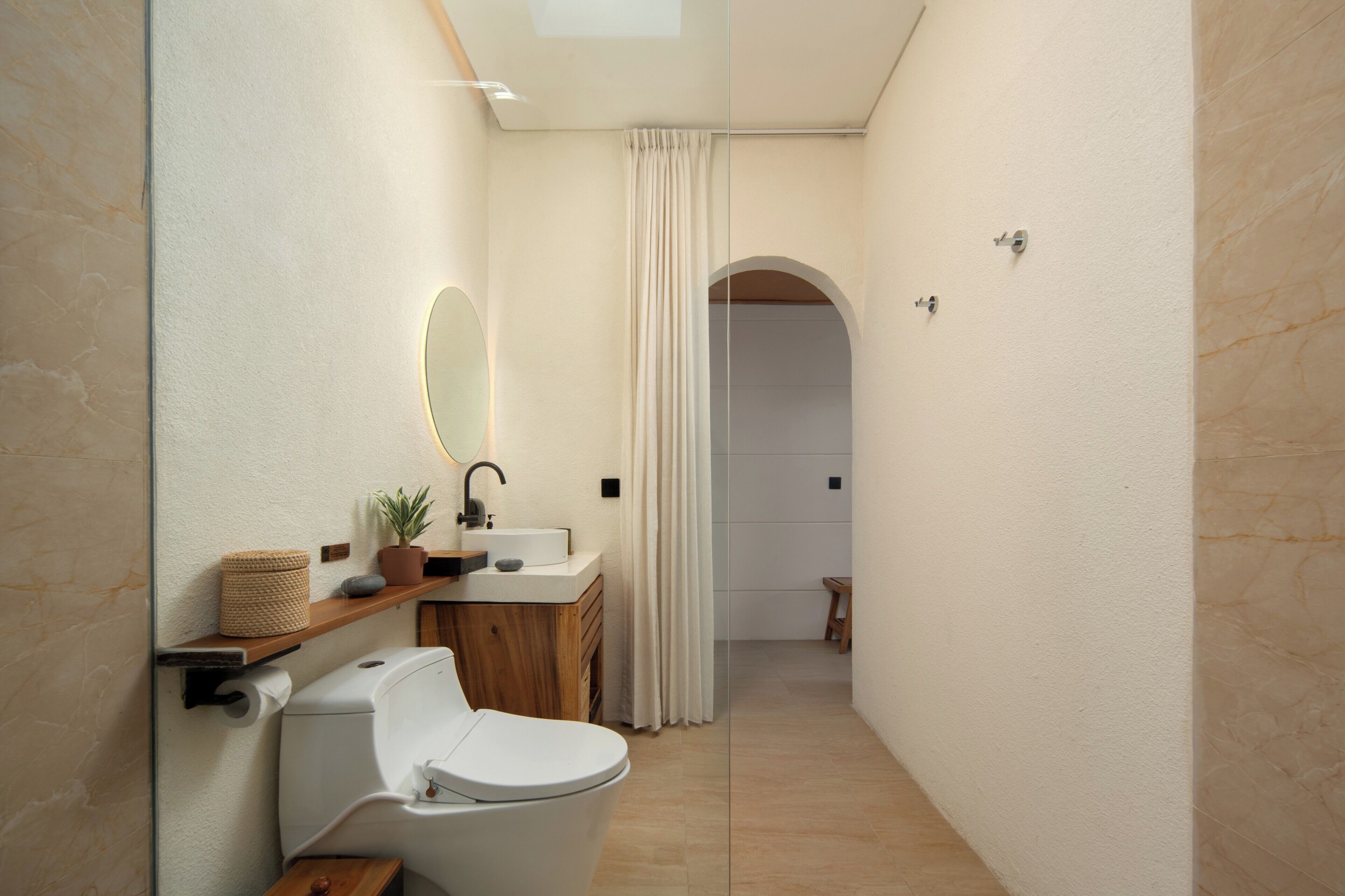 A modern bathroom with a toilet, sink, and mirror.