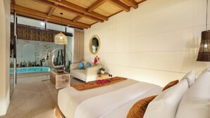 Un dormitorio con una cama grande, techo de madera, pared de piedra, espejo redondo y vista a una piscina.