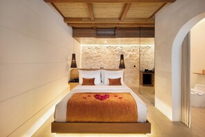 Experience a serene retreat with a large bed, pendant lights, and a clean-lined bathroom.