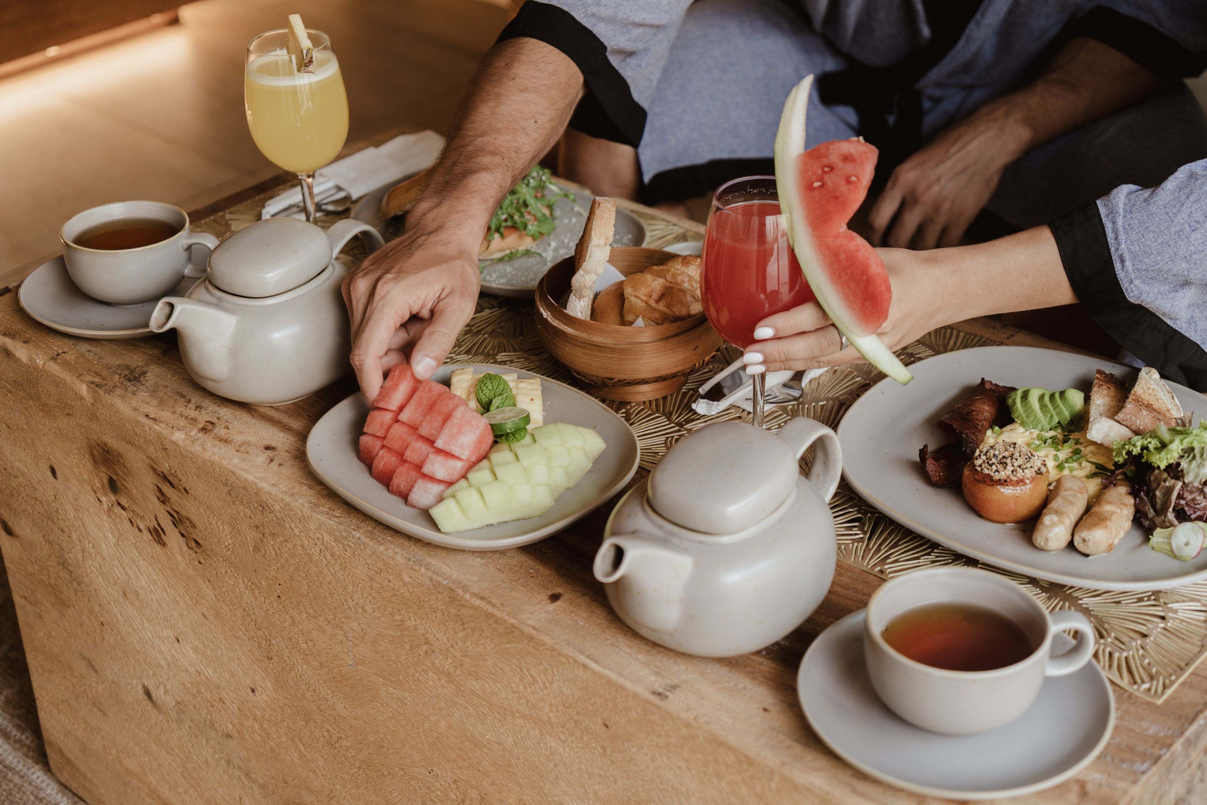 Una colazione con diversi cibi e bevande su un tavolo di legno.