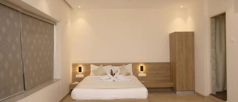 A modern bedroom with a wooden bed, bedside lamps, a ceiling fan, and a large window with blinds.