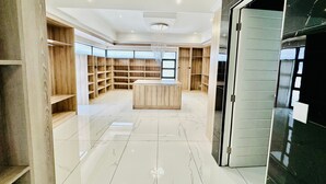 Um quarto espaçoso com uma ilha central, estantes embutidas e um lustre.