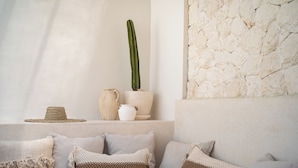 A cozy seating area with a cactus, woven basket, and rustic pottery. - Villa Kasih Satu (Gili Trawangan)