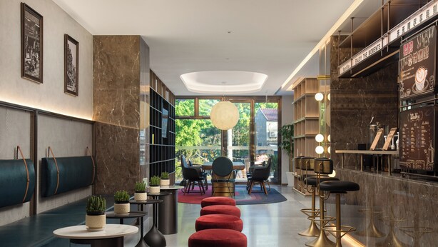 A modern interior with a seating area, a bar, and a view of greenery outside. - Wanda Yuehua Shanghai Wildlife Park (Shanghai)