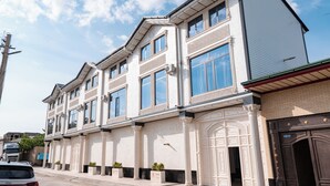 A multi-story building with large windows and a prominent entrance. - GOLD STAR PALACE HOTEL (Samarkand)