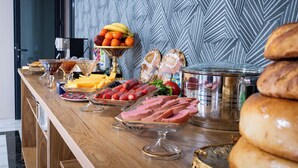 A buffet table with various food items including fruits, meats, and bread. - GOLD STAR PALACE HOTEL (Samarkand)