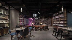 Uma biblioteca moderna com estantes, mesas e cadeiras.