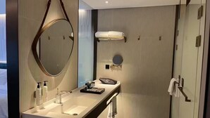 Um banheiro moderno com um espelho grande, uma pia ampla e um porta-toalhas.