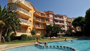 Un resort con piscina, varios balcones y palmeras.