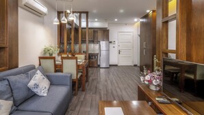 A modern living room with a sofa, dining table, and TV.