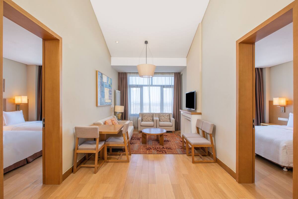 Une chambre d’hôtel avec un lit, un canapé, une table basse et un téléviseur.